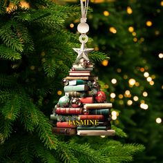 a christmas tree ornament made out of books and ornaments hanging from it's sides