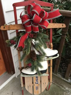 an old sled is decorated with red and white ribbons, pine cones, and skis