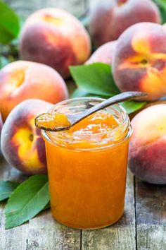 homemade low sugar peach jam in a mason jar with fresh peaches behind it and text overlay