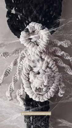 a black and white photo of a stuffed animal made out of rope on top of plastic