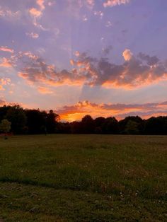 the sun is setting over an open field