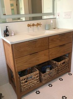 a bathroom vanity with two baskets under the sink