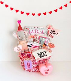 a valentine's day gift basket with teddy bears, hearts and other things in it