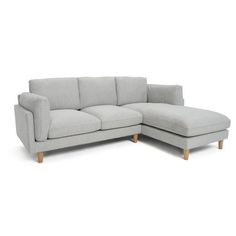 a grey sectional sofa with wooden legs on an isolated white background