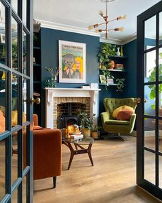 a living room filled with furniture and a fire place next to a window covered in plants