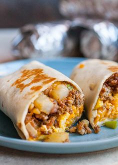 two burritos on a blue plate sitting on a table