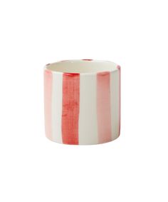 a red and white striped cup sitting on top of a table