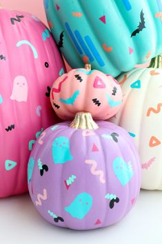 three painted pumpkins sitting next to each other