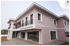 a pink house with white trim and balconies