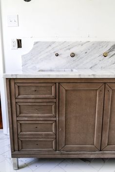 a bathroom vanity with marble top and drawers