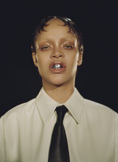 a young man wearing a white shirt and black tie with his nose ring in front of him