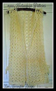 a white crocheted vest hanging on a wall