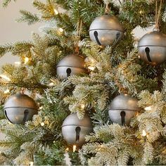 a christmas tree with bells hanging from it's branches and lights on the top