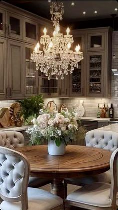 a dining room table with chairs and a chandelier hanging from the ceiling above it