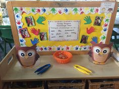 two owl puppets sitting on top of a wooden table next to scissors and other items