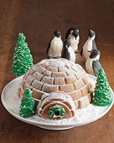 there is a cake decorated with penguins and trees