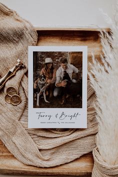 a couple and their dog sitting next to each other in front of a wooden frame