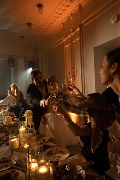 a group of people standing around a dinner table