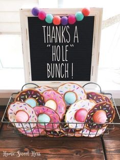 a basket filled with lots of donuts next to a sign that says, thanks a hole bunch