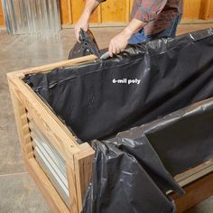 a man sanding down some sort of box with plastic covering it's sides