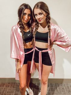 two women in matching outfits posing for the camera