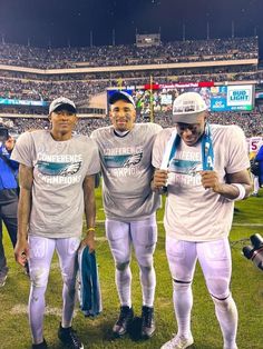 three football players are standing on the field at a game with fans in the stands