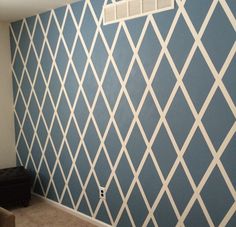 an empty room with blue and white wallpaper on the walls, air conditioner in the corner