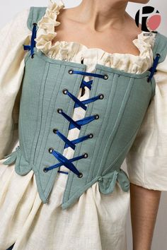 a woman wearing a green corset with blue laces on it's waist