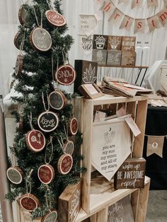 a christmas tree made out of wooden crates with ornaments on them and hanging from the top