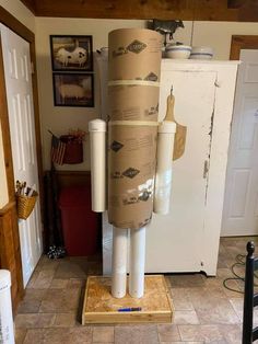 a refrigerator is wrapped in brown paper and placed on top of a cardboard box with two rolls of toilet paper attached to it