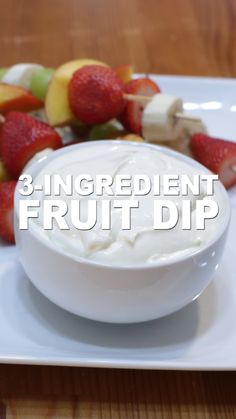 a white plate topped with fruit on top of a wooden table next to a bowl of yogurt