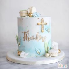 a blue cake with gold lettering and seashells on it