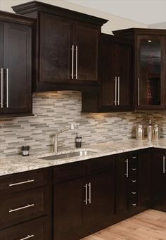 a kitchen with dark wood cabinets and white marble counter tops is seen in this image