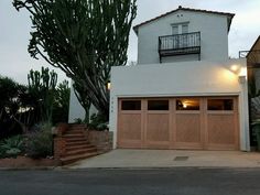 a white house with wooden garage doors and lights