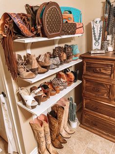 a closet filled with lots of shoes and purses on shelves next to a dresser