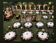 an aerial view of tables and chairs set up in the middle of a lawn area