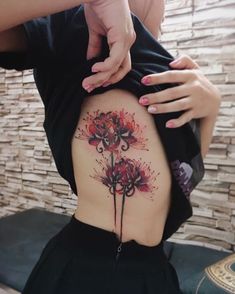 a woman's lower back tattoo with flowers on it