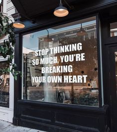 a store front with a sign in the window that says stop thinking so much you're breaking your own heart