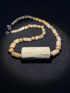 old ancient antique roman cylinder seal with stone age crystals quartz beads by uddiyanaart on Etsy Ancient Handmade Ceremonial Jewelry, Handmade Ancient Ceremonial Jewelry, Handmade Ancient Jewelry For Ceremonial Use, Ancient Style Gemstone Beads Jewelry Gift, Ancient Style Gemstone Beads Jewelry For Gift, Gold Carved Round Beads Jewelry, Gold Carved Beads Jewelry, Ancient Handmade Healing Necklace, Bohemian Carved Jewelry For Healing