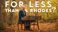 a man sitting at a table in the middle of a forest with leaves on the ground