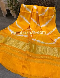 "Smooth and silky tie-dye mashru silk dupatta with \"lagdi patta\"." Summer Yellow Dupatta With Cutdana, Yellow Cutdana Dupatta For Summer, Summer Art Silk Dupatta With Pallu, Yellow Bohemian Dupatta With Bandhani Print, Festive Silk Dupatta With Batik Print, Yellow Silk Dupatta For Summer, Summer Yellow Silk Dupatta, Bohemian Raw Silk Dupatta With Bandhani Print, Bohemian Bandhani Print Raw Silk Dupatta