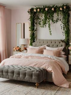 a bedroom decorated in pink and grey with flowers on the headboard, bedding, and pillows