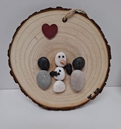 a wooden slice with some rocks and a heart on it