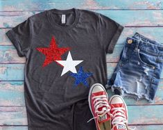 a pair of red, white and blue converse shoes next to a t - shirt