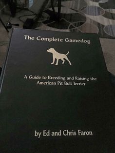 the complete game dog book sitting on top of a bed