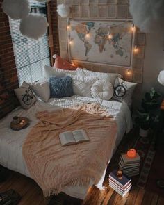 a bed with pillows and blankets on top of it in a bedroom next to a brick wall