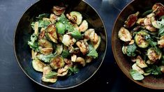 two brown bowls filled with food on top of a black table next to each other