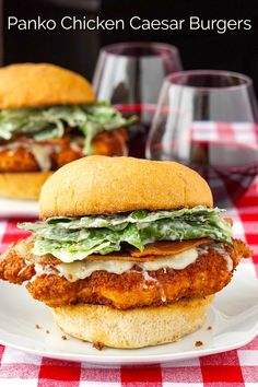 two chicken caesar burgers sitting on top of a white plate