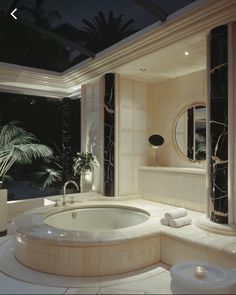 a bathroom with a large jacuzzi tub next to a window and palm trees