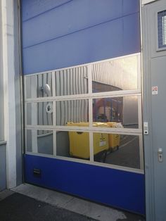 a blue and white garage door with the reflection of a yellow box on it's side